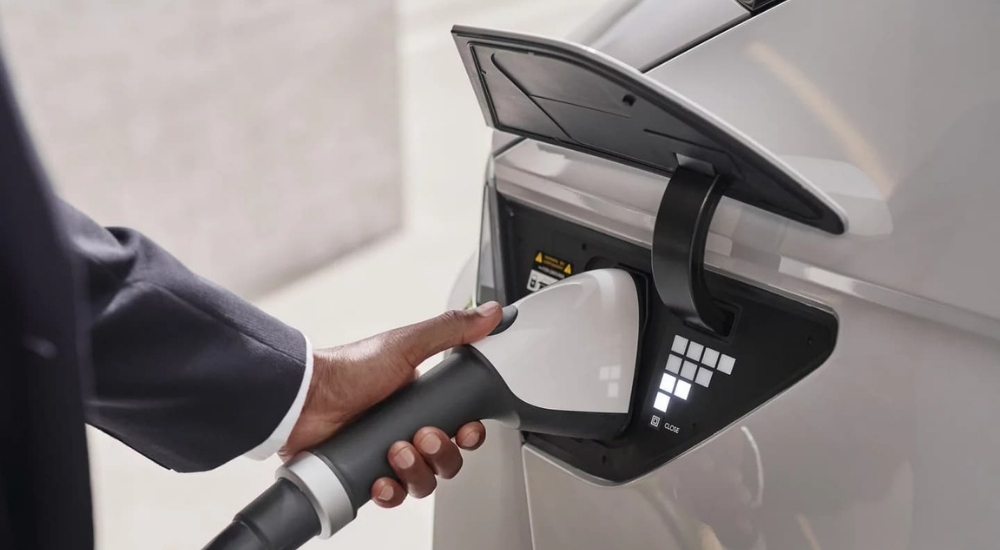A close up shows a person charging a white  2023 Hyundai IONIQ 5.