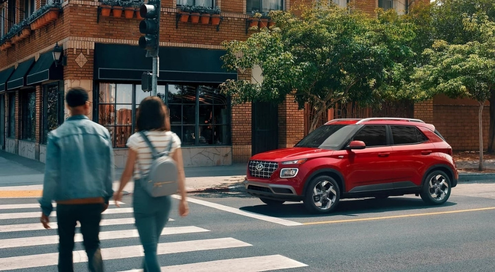 A red 2023 Hyundai Venue Limited is shown at an intersection after leaving a Hyundai dealer near Libertyville.