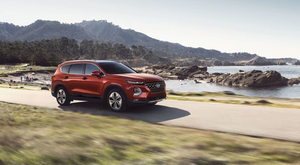 A red 2019 Hyundai Santa Fe driving down a road.