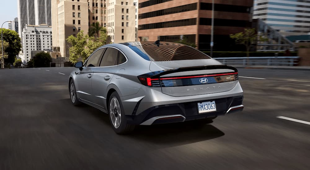 Grey 2025 Hyundai Sonata driving on a city street.