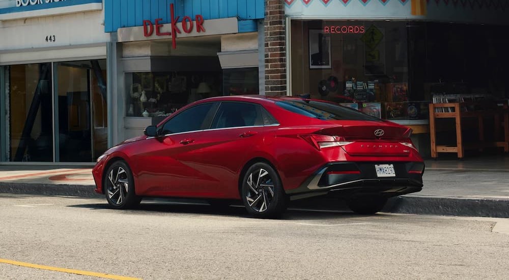 A red 2025 Hyundai Elantra parked near a record store.