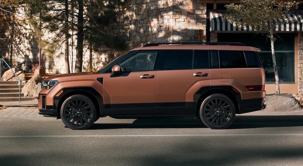 A copper 2026 Hyundai Santa Fe Hybrid SE parked in a city.