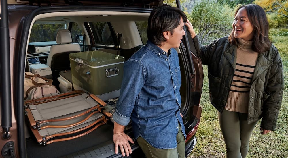 Two people standing next to the open lift gate on a 2026 Hyundai Santa Fe