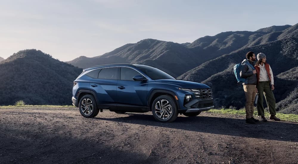 A blue 2026 Hyundai Tucson parked near hikers.