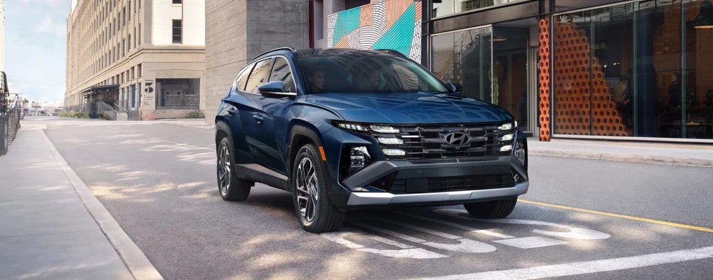 Blue 2025 Hyundai Tucson Limited driving on a city street