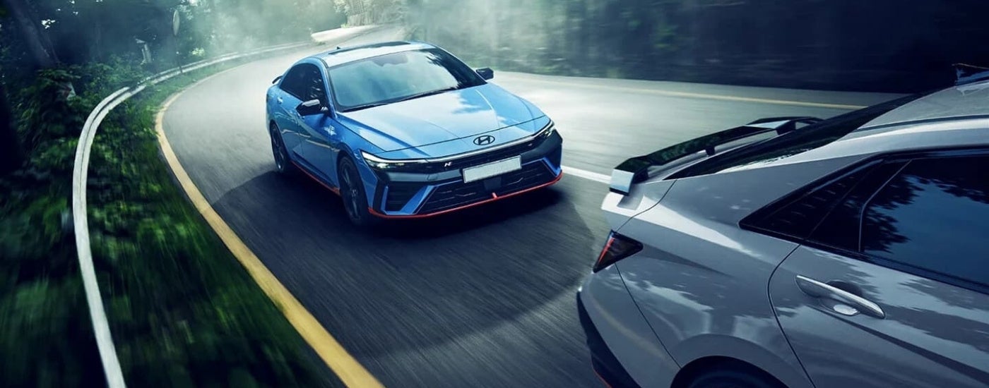 A blue 2024 Hyundai Elantra N is shown driving to a Hyundai dealer near Grayslake.