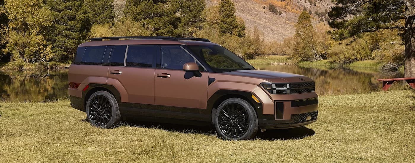 A bronze 2025 Hyundai Santa Fe is shown from the side.