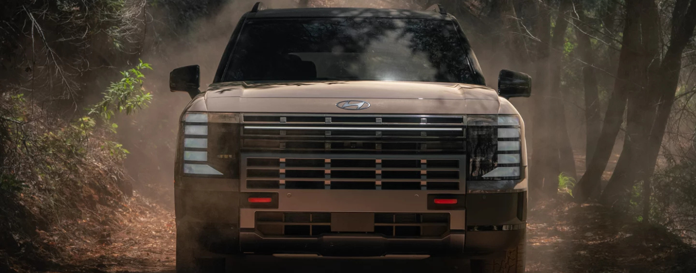 Brown 2026 Hyundai Palisade XRT driving down a muddy trail