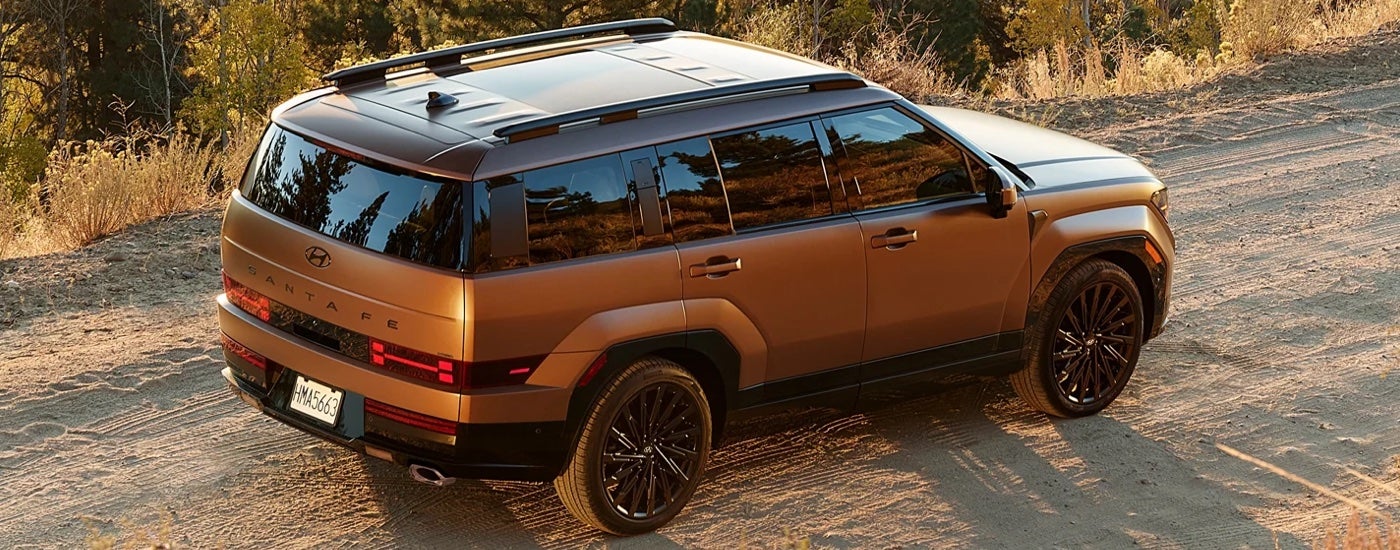Overhead view of a copper colored 2024 Hyundai Santa Fe parked on a dirt road.